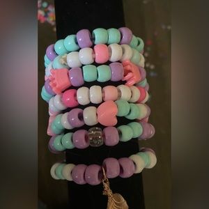 Bracelet set of seven, with Tiana charm. Purple themed.